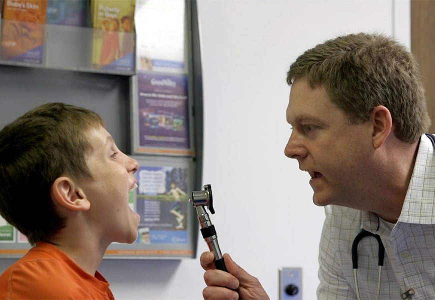 doctor looking in child's throat
