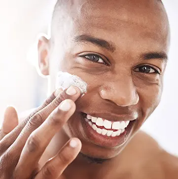 Man putting lotion on his face