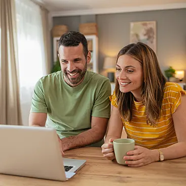 A man and a woman looking at a laptop