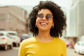 Black woman smiling and wearing sunglasses