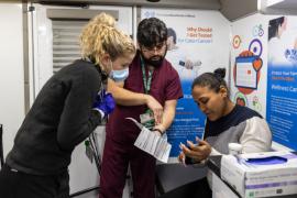 Rush staff members work with a patient in a clinical space