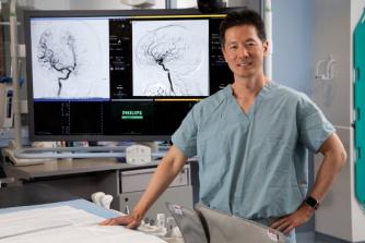 Dr. Michael Chen in front of brain scans
