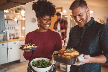 Woman and man smiling preparing to eat a holiday meal