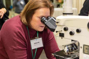 Deborah Hall looks into a microscope.