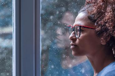 Woman staring out window at snow