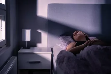 Woman sleeping with bright light shining through window