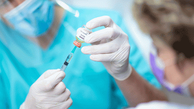 Nurse hold COVID vaccine vial
