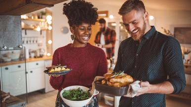 Woman and man smiling preparing to eat a holiday meal