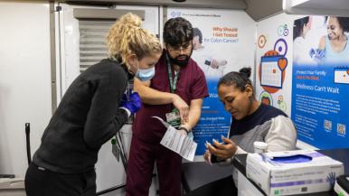 Rush staff members work with a patient in a clinical space