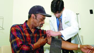 Man getting blood pressure taken by doctor