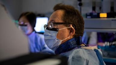 irving waxman wearing a mask and spectacles during a procedure in an operating room