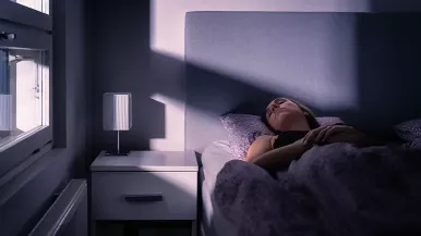 Woman sleeping with bright light shining through window