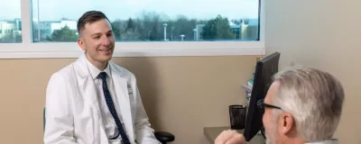 Doctor Skertich at desk talking with patient about Gastric Sleeve Surgery.